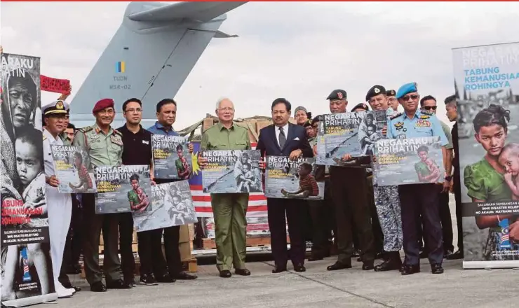  ?? PIC BY EIZAIRI SHAMSUDIN ?? Prime Minister Datuk Seri Najib Razak showing a poster of the ‘Negaraku Prihatin’ campaign at the Subang airbase yesterday.