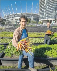  ?? ARLEN REDEKOP ?? Michael Ableman, foreground, seen with Alain Guy at False Creek Sole Food farm, is hosting a fundraisin­g dinner on Oct. 6 with some of the city’s top chefs at the Sole Food orchard at Main and Terminal.