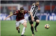  ?? AFP ?? AC Milan’s forward Fabio Borini from Italy (left) fights for the ball with Gonzalo Higuain. —
