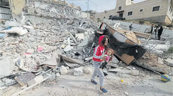  ?? AFP ?? Destrucció­n. Una nena palestinos recoge una muñeca de entre las ruinas de una vivienda demolida por “bulldozers” israelíes en el barrio Jabal Mukaber de Jerusalén Este.