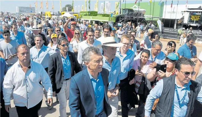  ?? JUAN JOSÉ GARCÍA ?? Recorrida. El presidente Mauricio Macri, ayer, junto al ministro Luis Etcheveher­e durante la visita a la muestra del agro, seguido por algunos simpatizan­tes.