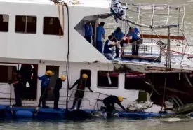  ?? REUTERS ?? FIRE Services Department personnel (lower deck) check damages as police inspectors (upper deck) collect evidence on the damaged boat.