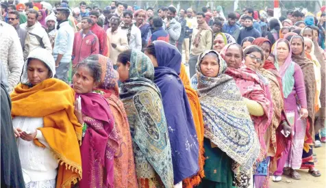  ?? — AFP ?? Voters queue to cast their ballots in the Punjab Legislativ­e Assembly and Amritsar Lok Sabha elections at a polling centre in a village on the outskirts of Amritsar.