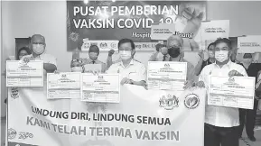  ?? — Gambar Bernama ?? PEMBERIAN VAKSIN: Chow (tiga kanan) bersama Ahmad Zakiyuddin (dua kanan) dan P. Ramasamy (kiri) menunjukka­n kad vaksinasi COVID-19 selepas mendapat suntikan vaksin COVID-19 jenis Pfizer-BioNTech pada Upacara Permulaan Program Imuninasi COVID-19 Fasa Satu di Pusat Pemberian Vaksin COVID-19 di Hospital Puau Pinang, George Town semalam.