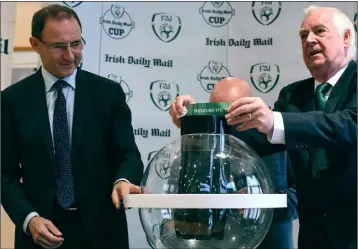  ??  ?? FAI President Tony Fitzgerald picks Wexford Youths out of the hat during the Irish Daily Mail FAI Senior Cup third round draw at the Clonmel Park Hotel on Friday, as Republic of Ireland team manager Martin O’Neill looks on. Youths will be at home to...