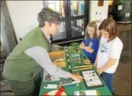  ?? PHOTO SPECIAL TO THE DISPATCH BY MIKE JAQUAYS ?? Archaeolog­ist Dr. Amy Roache-Fedchenko, left, shows Sarah Fitzgerald, center, of Vienna and Abigail Miller of Florence some of the artifacts discovered at Fort Stanwix in Rome Oct. 7during Internatio­nal Archeology Day.