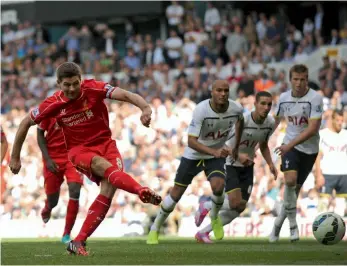  ?? — AFP ?? Liverpool's Steven Gerrard scores against Tottenham Hotspur during their English Premier League match at White Hart Lane in London on Sunday. The Reds won 3- 0.