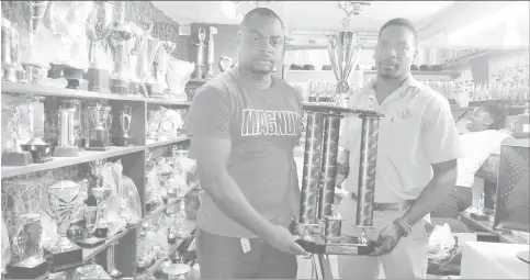  ??  ?? Magnum Tonic Wine Brand Representa­tive Edison Jefford (left) handing over the Championsh­ip trophy to LABA President Lawrence Simon for the Division-1 League at the Trophy Stall Bourda location