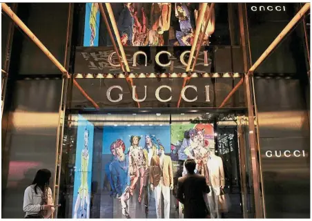  ?? — Reuters ?? Strong demand: A man looks at a window display outside a Gucci store in Hong Kong. The group says demand from Chinese clients remain ‘extremely dynamic,’ and the ‘trend remains excellent’ on the mainland.