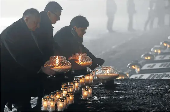  ?? /Reuters ?? Remembranc­e: Undersecre­tary of State at the Chanceller­y of the President of Poland Wojciech Kolarski, Polish Prime Minister Mateusz Morawiecki and Deputy Prime Minister Beata Szydlo place candles at the Monument to the Victims at the former Nazi German...