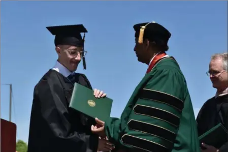  ?? NICHOLAS BUONANNO -MEDIANEWS GROUP ?? Nic Smith, left, grabs his diploma from HVCC President Roger Ramsammy.