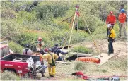  ?? ?? DANGEROUS WATERS: Members of a rescue team work at a site where three bodies were found in the state of Baja California on Friday.