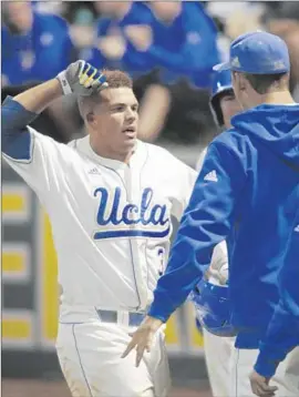  ?? Lawrence K. Ho Los Angeles Times ?? DARRELL MILLER JR., left, is greeted by UCLA teammates after scoring in the second inning against Maryland. The Bruins led, 4-2, through seven innings.