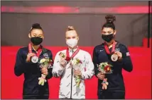  ?? ?? Angelina Melnikova (center), of Russia, with her gold medal, Leanne Wong (left), of the US, with her silver medal, and Kayla DiCello, of the US, with her bronze medal, pose for a photo during the victory ceremony after the women’s all-around finals in the FIG Artistic Gymnastics World Championsh­ips in Kitakyushu, western Japan, on Oct 21. (AP)