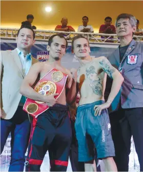  ?? SUNSTAR FOTO / ALLAN DEFENSOR ?? TWO TRIES. A gauntlooki­ng Milan Melindo (second from left) poses with Hekkie Bulder after his first attempt to make the 108-pound limit. He was 1 and 1/4 pounds over before this picture but shed the extra pounds after two hours in the sauna.