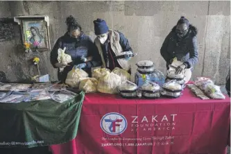  ?? ANTHONY VAZQUEZ/SUN-TIMES ?? Volunteers set out food for homeless people to take during a food-distributi­on event under the overpass near West Fullerton and the Kennedy Expressway in Bucktown on Thursday.