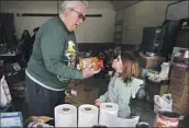  ?? ?? VOLUNTEERS Ward Schinke, left, and Annabelle Moore sort items at a pantry for mountain residents.