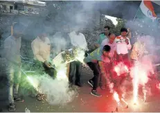  ?? AJIT SOLANKI/THE ASSOCIATED PRESS ?? Indians hold posters of Indian naval officer Kulbhushan Jadhav and light fire crackers as they celebrate the Internatio­nal Court of Justice order stopping Pakistan from executing him.