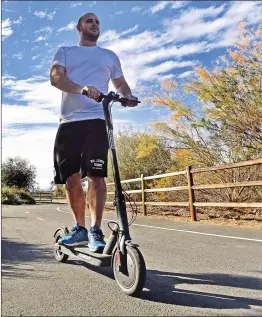  ?? Dan Watson/The Signal ?? Josh Manheim of Valencia rides his electric scooter on the paseo near the Iron Horse Trail head in Valencia on Tuesday.