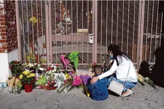  ?? Jae C. Hong/Associated Press ?? A woman comforts her son while visiting a makeshift memorial outside Star Ballroom Dance Studio, where a gunmen opened fire killing 11 people in Monterey Park (Los Angeles County).