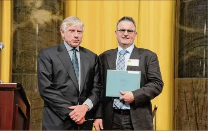  ?? Dave Kotinsky/Getty Images ?? Lee C. Bollinger, left, presents an award to Gilbert King at the 7th Annual Pulitzer Prizes in Journalism, Letters, Drama and Music Winners Luncheon in 2013. King helped produce the podcast "Bone Valley," released in 2022, and will speak about it on Wednesday, Feb. 1 as part of the New York State Writer's Institute's season.