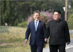  ?? KOREA SUMMIT PRESS POOL VIA AP ?? North Korean leader Kim Jong Un, right, and South Korean President Moon Jae-in walk together Friday at the border village of Panmunjom in the Demilitari­zed Zone, South Korea.