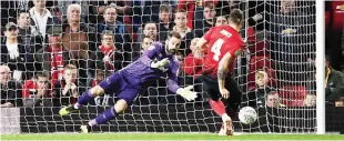  ??  ?? Derby’s Scott Carson dives to save a penalty from Manchester United’s Phil Jones. — AFP photo