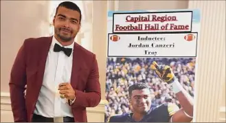  ?? Sean Martin / Special to the Times Union ?? Former Troy High star and Iowa standout Jordan Canzeri stands near his induction poster at the Capital Region Football Hall of Fame induction ceremony on Saturday.