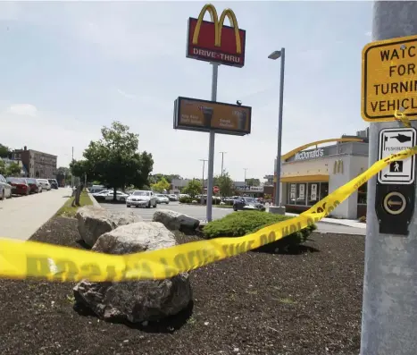  ?? PAUL CONNORS / BOSTON HERALD ?? UNDER INVESTIGAT­ION: A piece of Boston Police crime scene tape is seen outside a McDonald’s restaurant where a triple shooting occurred around 11 p.m. on Friday in the area of Dale and Warren streets in Roxbury.