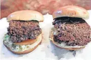  ?? [AP PHOTO] ?? A convention­al beef burger, left, is seen Friday next to “The Impossible Burger”, right, a plant-based burger containing wheat protein, coconut oil and potato protein among it’s ingredient­s.