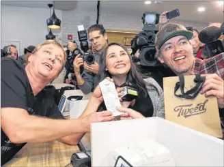  ?? CP PHOTO ?? Canopy Growth CEO Bruce Linton, left to right, poses with the receipt for the first legal cannabis for recreation use sold in Canada to Nikki Rose and Ian Power at the Tweed shop on Water Street in St. John’s N.L. at 12:01 am NDT on Wednesday.