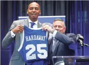  ?? MARK ?? Penny Hardaway holds up his old jersey with AD Tom Bowen (right) while being introduced. WEBER/THE COMMERCIAL APPEAL