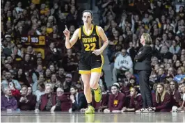  ?? ABBIE PARR / AP ?? Iowa guard Caitlin Clark (22) points after an Iowa basket scored during the first half of an NCAA college basketball game against Minnesota in Minneapoli­s on Wednesday. Clark will skip her final season of college eligibilit­y for the WNBA draft.