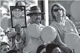  ?? GUSTAVO ANDRADE/AP ?? A man holds a portrait of a victim who died in the 2019 dam disaster in Brumadinho city, Minas Gerais state, Brazil. On Saturday, relatives of victims had a memorial.