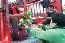  ?? XIE JIANFEI / XINHUA ?? Vegetables donated by Sichuan province are distribute­d last month to residents of Xiangyang in Hubei, the Chinese province hardest hit by COVID-19.