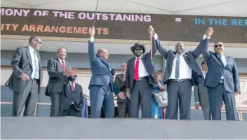 ?? — Reuters ?? South Sudan’s President Salva Kiir holds hands with rebel leader Riek Machar as Sudan’s President Omar al Bashir and Kenya’s President Uhuru Kenyatta witness before the signing of a power sharing agreement in Khartoum, Sudan.
