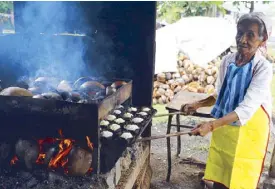  ??  ?? Rosela Jagonal cooks and sells bibingka in Manticao.