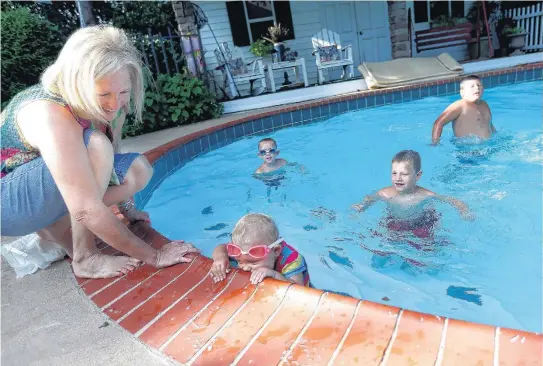  ??  ?? Cathy Mathes watches Kyleigh as as Nathan, Brent and Blake swim at their home.