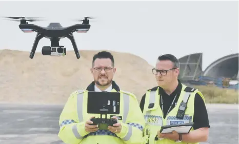  ??  ?? Cambs police with their new joint operations drone unit at RAFAlconbu­ry. Drone pilots Inspector Chris Huggins (letf) and PC Liam Denman.