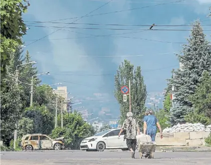  ?? ?? Vida. Pobladores de la ciudad de Lysychansk, región de Lugansk, tratan de conseguir alimentos.REUTERS