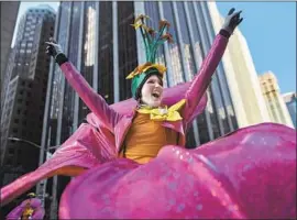  ?? Andres Kudacki Associated Press ?? A PERFORMER in f lowery cap and warm gloves greets the crowd on New York’s 6th Avenue in the Macy’s Thanksgivi­ng Day Parade. It was 21 degrees at the start.