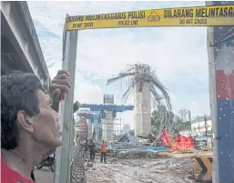  ??  ?? WORK IN PROGRESS: A man stands near a collapsed girder pole on the constructi­on site of the Bekasi-Cawang toll overpass in Jakarta.