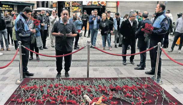  ?? FOTO: KHALIL HAMRA/AP ?? Ein Mann betet vor dem abgesperrt­en Anschlagso­rt. Viele Menschen haben Blumen als Zeichen der Trauer niedergele­gt.