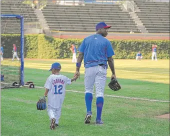  ?? | GETTY IMAGES ?? Alfonso Soriano, who has terrorized AL pitchers, walks to the outfield with his son Wednesday.