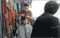  ??  ?? From top: Workers dine in a restaurant after work. Spicy hot pot dishes are popular due to the humid climate in Metog county; Akou Wuge, a 19-year-old Yi ethnic boy from Mabian, Sichuan province, asks his friend to help cut his hair that had not been groomed for half a year.