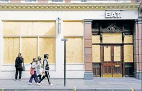  ??  ?? FOOLISH AND CAREFUL:
Bikini-clad sunworship­pers (above) crowd Sydney, Australia’s Bondi Beach just before cops threw them all out Saturday, while three masked Britons (left) pass by a boarded-up restaurant in central London. In the UK, 233 people have died from the coronaviru­s.