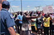  ??  ?? PROTEST: A low-cost house owner in Olievenhou­tbosch, Gauteng, protects it from angry residents who claim that the property was sold to her by a corrupt ward councillor .