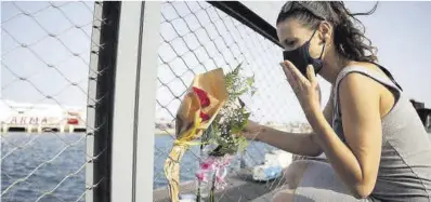  ?? Ramón de la Rocha ?? Una mujer deposita un ramo de flores en la cerca del puerto de Santa Cruz de Tenerife.