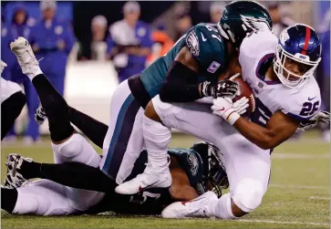  ?? AP PHOTO BY JULIO CORTEZ ?? New York Giants running back Saquon Barkley (26) is tackled by Philadelph­ia Eagles’ Malcolm Jenkins (27) during the first half of an NFL football game Thursday, Oct. 11, in East Rutherford, N.J.