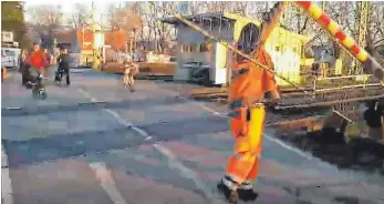  ?? FOTO: WOLFGANG KEHLE ?? Das Standbild aus dem Video zeigt, dass Bahnmitarb­eiter die defekten Schranken am Lotzbeckwe­g am Mittwoch zeitweise händisch öffnen mussten.